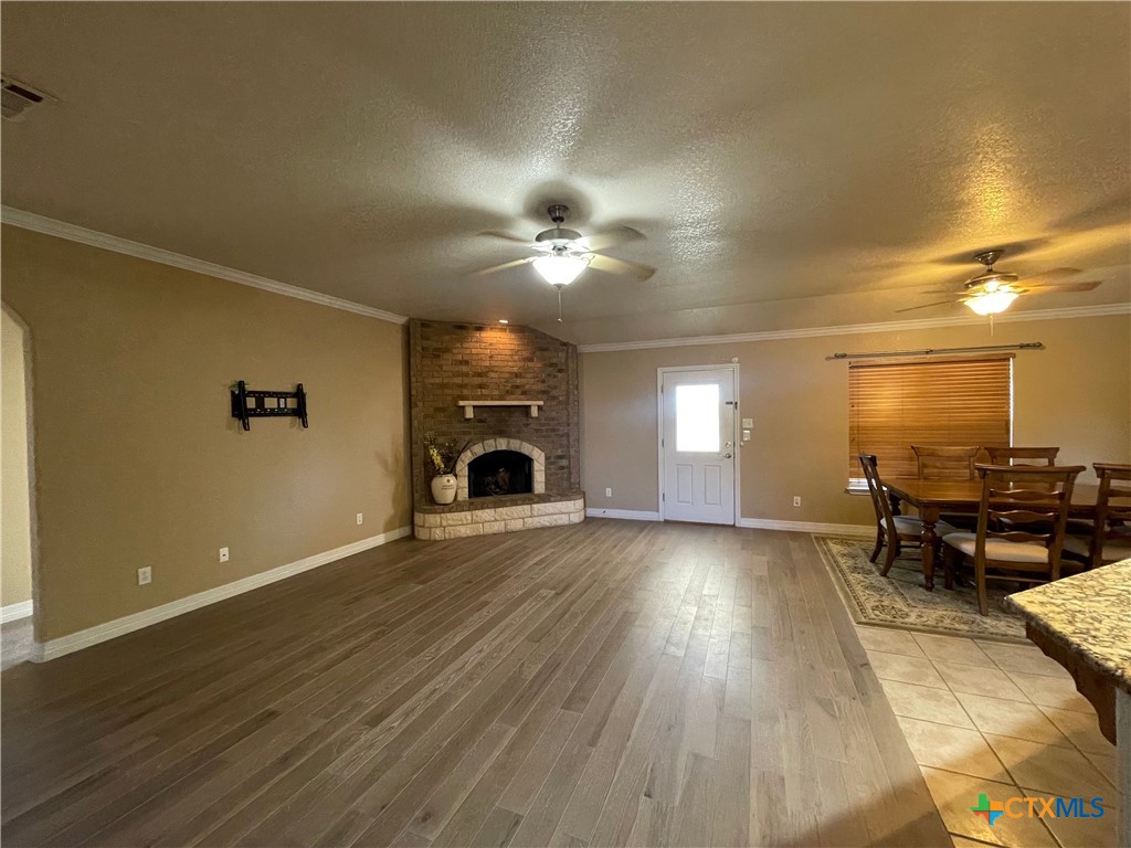 170 County Road 4709 Kempner, TX 76539 - Photo 9 of 24 an empty room with fireplace and wooden floor