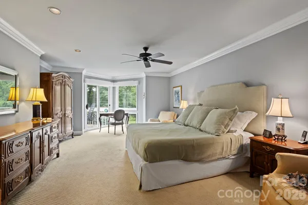 a bedroom with a bed a chandelier and a couch
