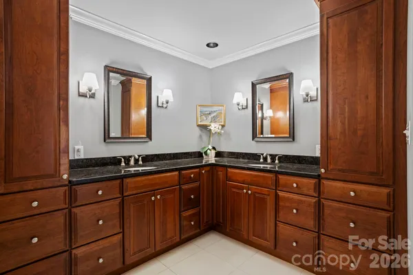 a bathroom with a granite countertop double vanity sink and mirror