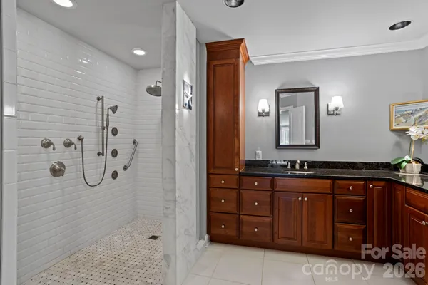 a spacious bathroom with a granite countertop sink mirror and shower