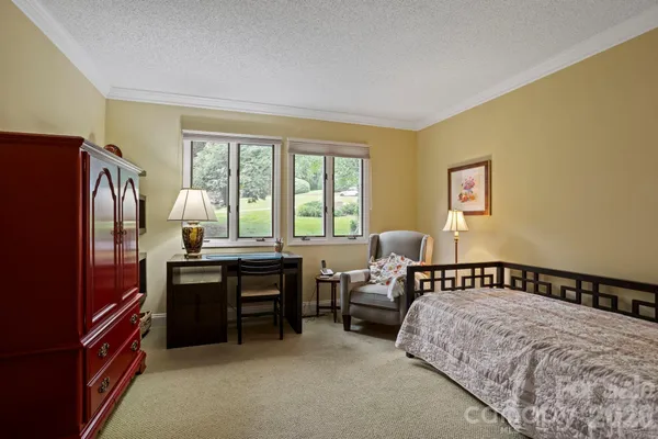 a bedroom with a bed and a refrigerator