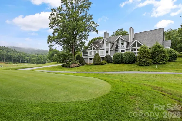 a view of a house with a big yard and potted plants