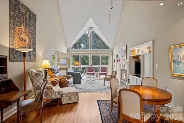 a living room with furniture a fireplace and a floor to ceiling window