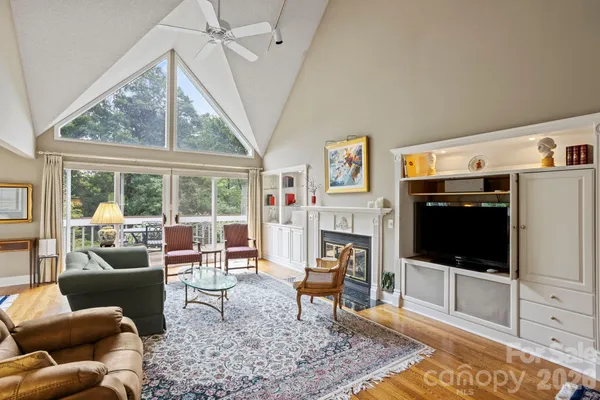 a living room with furniture a flat screen tv and a floor to ceiling window