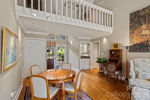 a living room with furniture a dining table and paintings on the wall next to a window