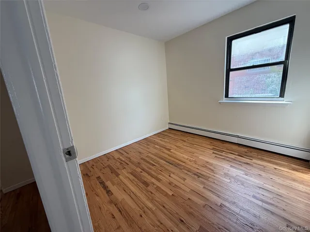 a view of a room with wooden floor and white walls