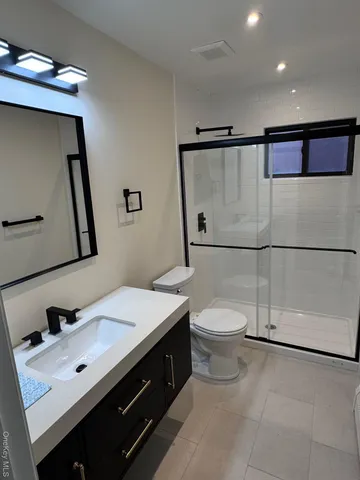 a bathroom with a toilet a sink and mirror