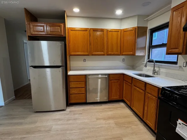 a kitchen with stainless steel appliances granite countertop a refrigerator a sink and a stove