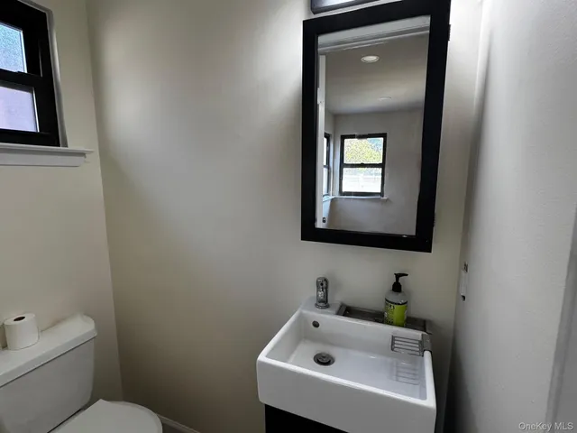 a bathroom with a toilet sink and mirror