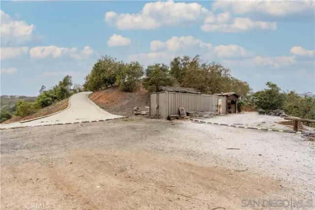 a view of a dry yard with trees
