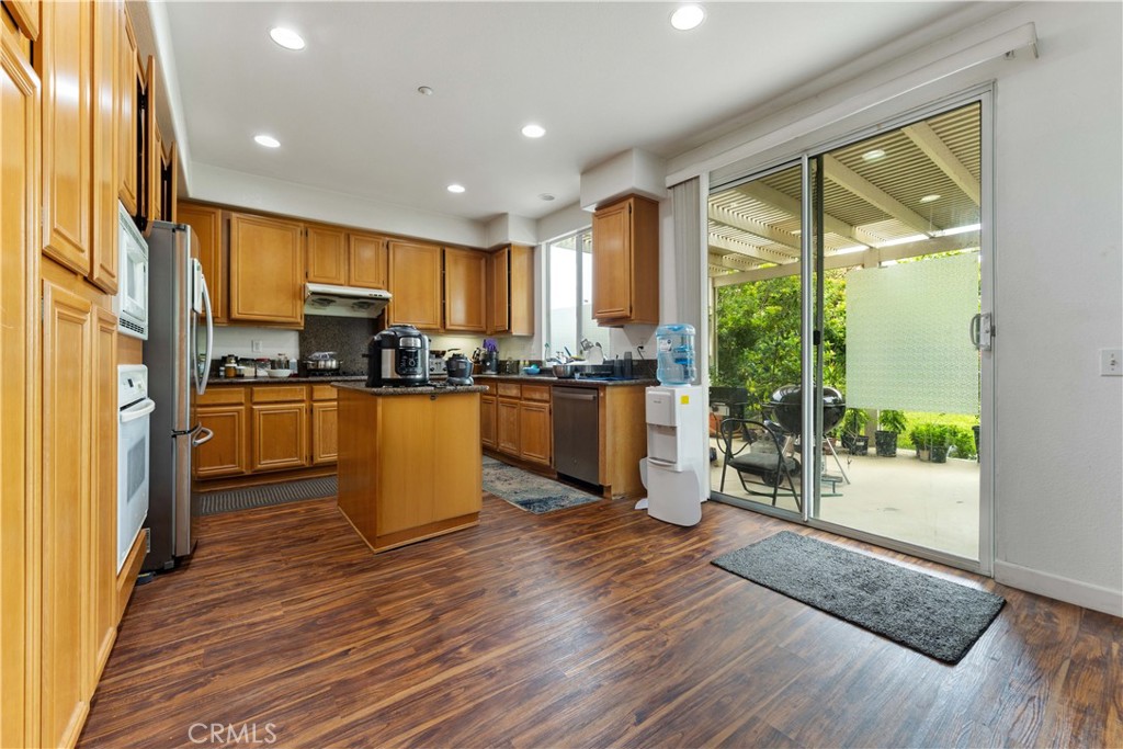 11390 Parkfield Court Riverside, CA 92505 - Photo 13 of 42 a kitchen with stainless steel appliances granite countertop wooden floor a refrigerator a sink and a stove