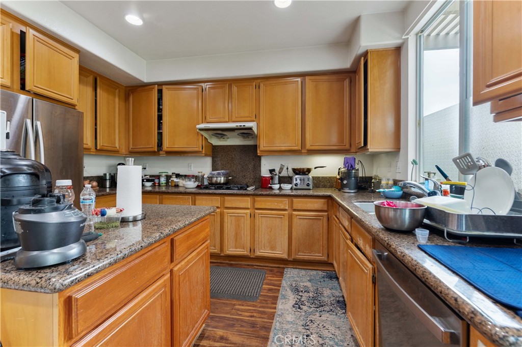 11390 Parkfield Court Riverside, CA 92505 - Photo 14 of 42 a kitchen with kitchen island granite countertop a sink and a stove top oven