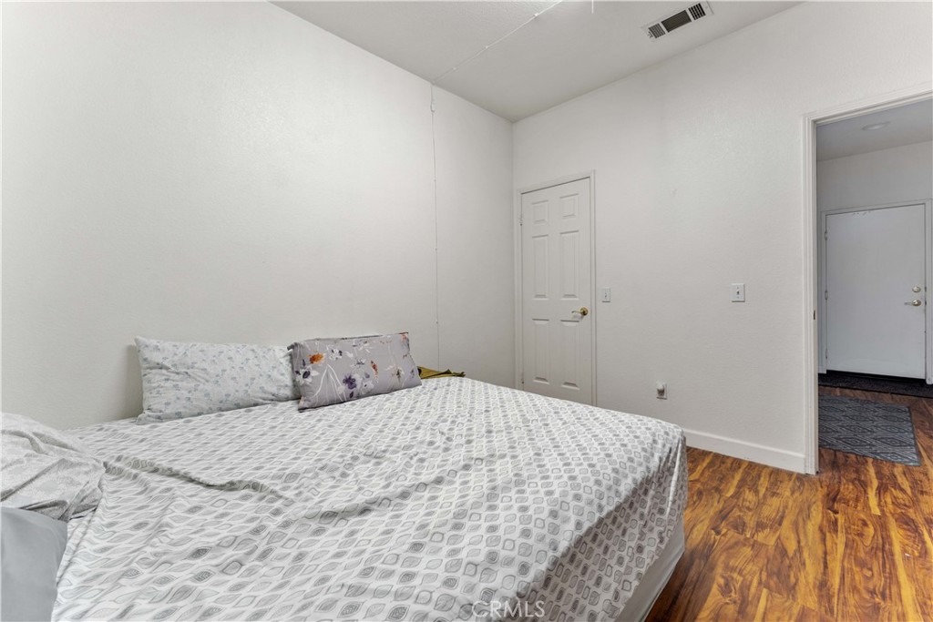 11390 Parkfield Court Riverside, CA 92505 - Photo 17 of 42 a bedroom with a bed and wooden floor