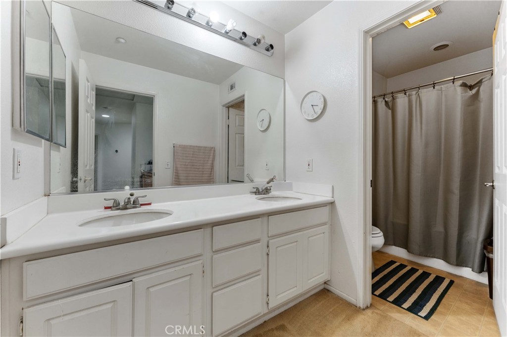11390 Parkfield Court Riverside, CA 92505 - Photo 24 of 42 a bathroom with a double vanity sink and a mirror