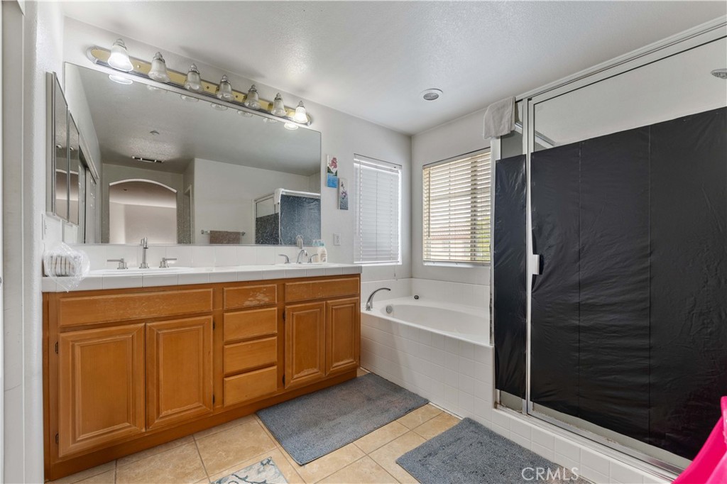 11390 Parkfield Court Riverside, CA 92505 - Photo 30 of 42 a spacious bathroom with a tub sink and mirror