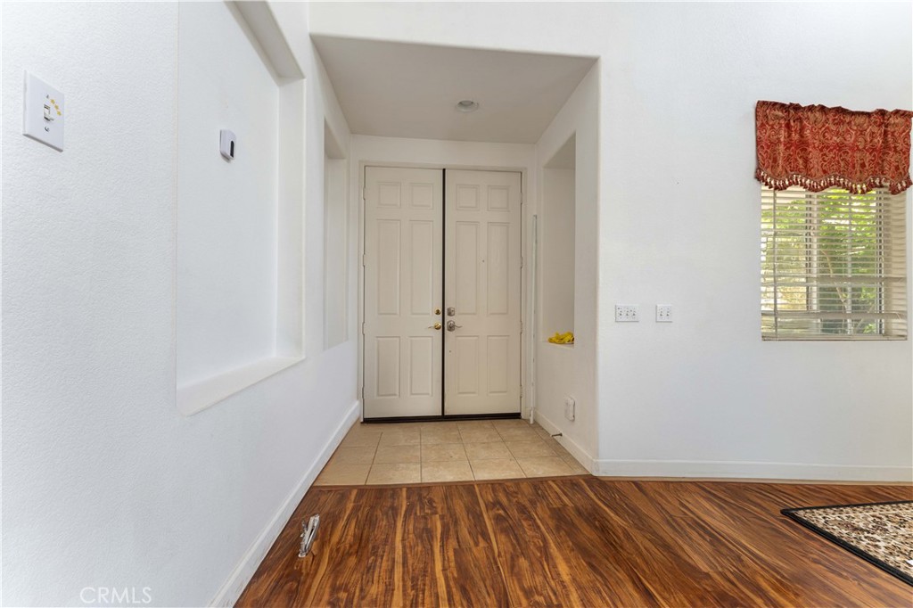 11390 Parkfield Court Riverside, CA 92505 - Photo 5 of 42 a view of a room with wooden floor and white walls