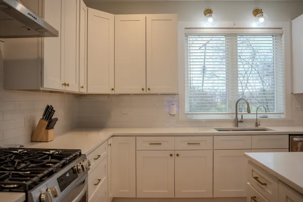 a kitchen with white cabinets and a stove top oven
