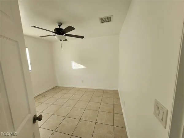 a view of a room with an empty space and a ceiling fan