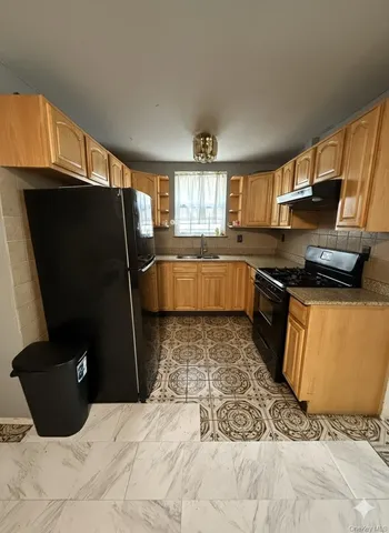 a kitchen with a sink a refrigerator and window