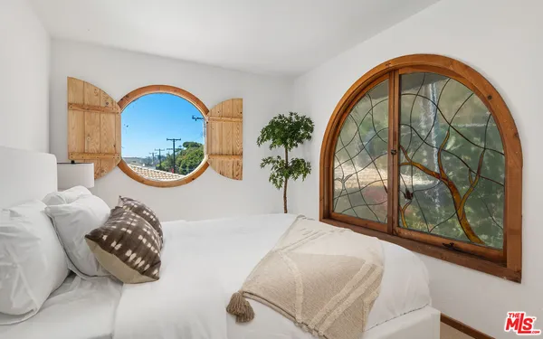 a bedroom with a large bed and a large window
