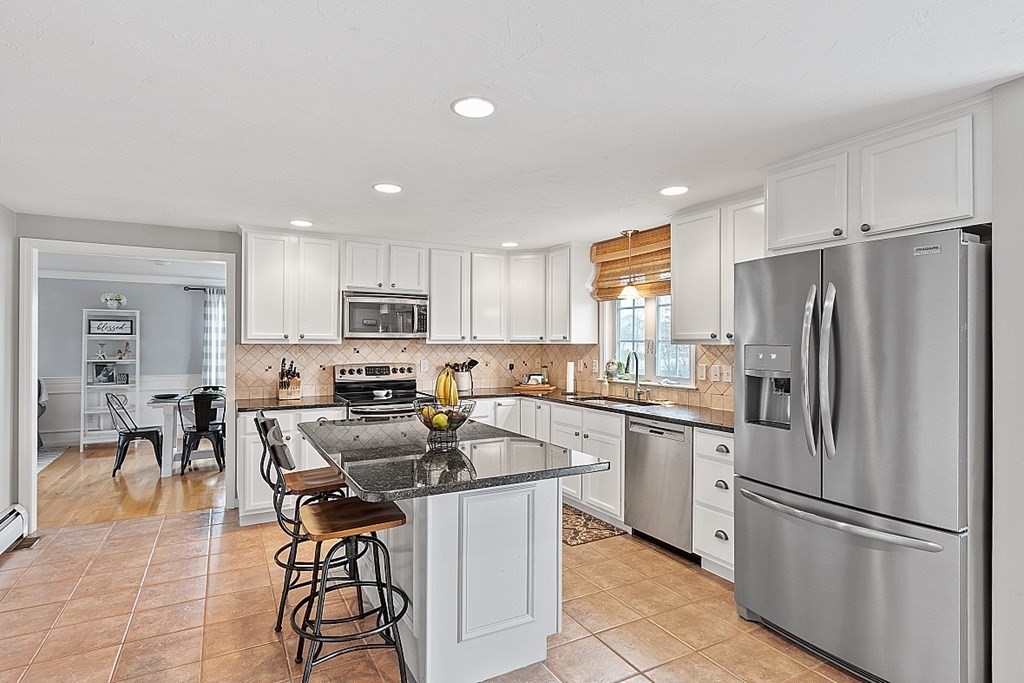 3 William Circle Rutland, MA 01543 - Photo 5 of 42 a kitchen with a refrigerator a stove a sink a dining table and chairs