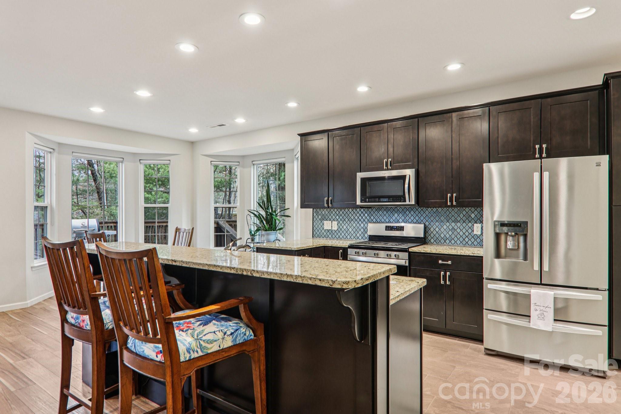29 Saddle Top Road Flat Rock, NC 28731 - Photo 20 of 46 a kitchen with stainless steel appliances granite countertop a stove a refrigerator a sink a dining table and chairs