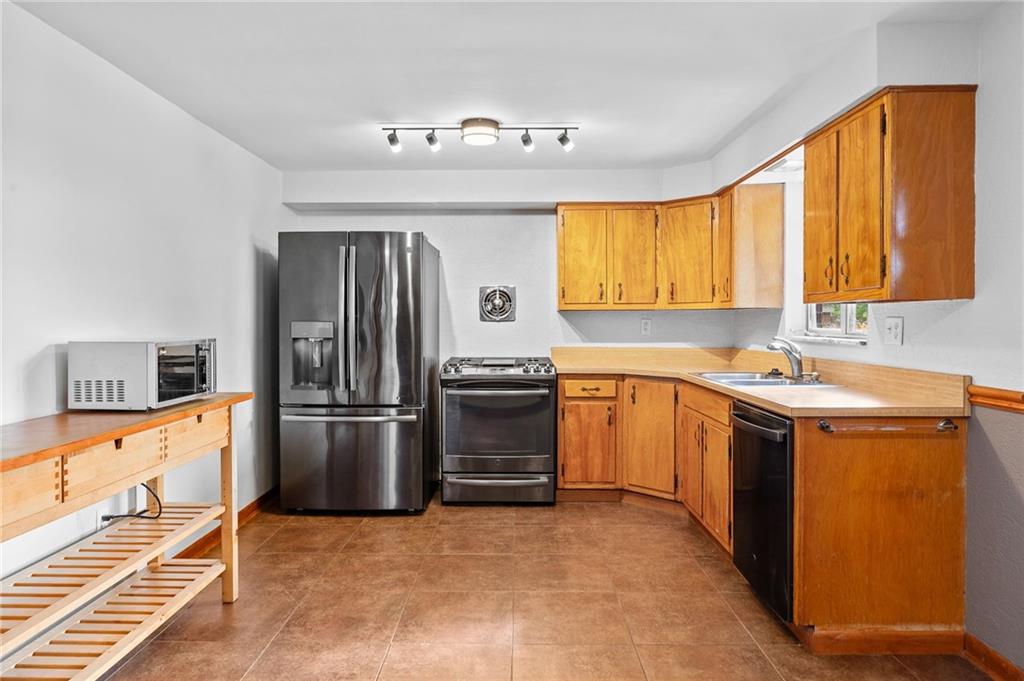 409 4th Street McDonald, PA 15057 - Photo 11 of 37 a kitchen with granite countertop a stove a sink and a refrigerator