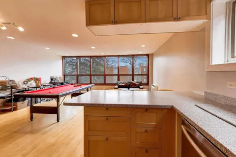 a room with stainless steel appliances kitchen island granite countertop a sink and cabinets