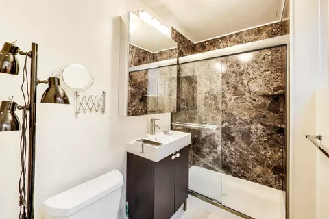 a bathroom with a sink vanity mirror and toilet