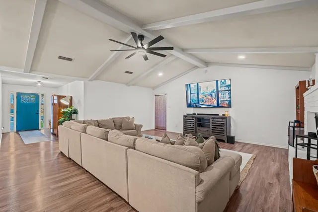 a living room with furniture and a wooden floor