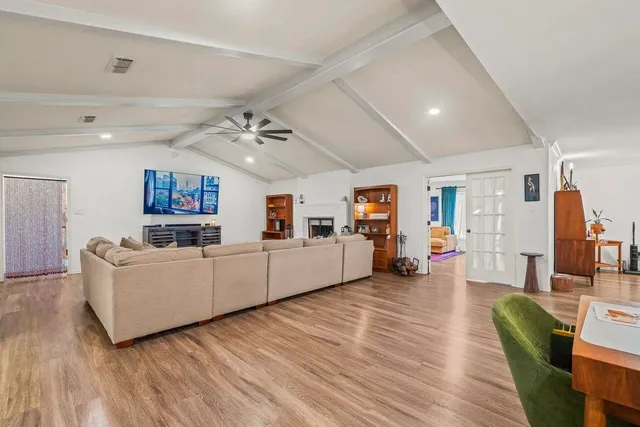 a living room with furniture and a wooden floor