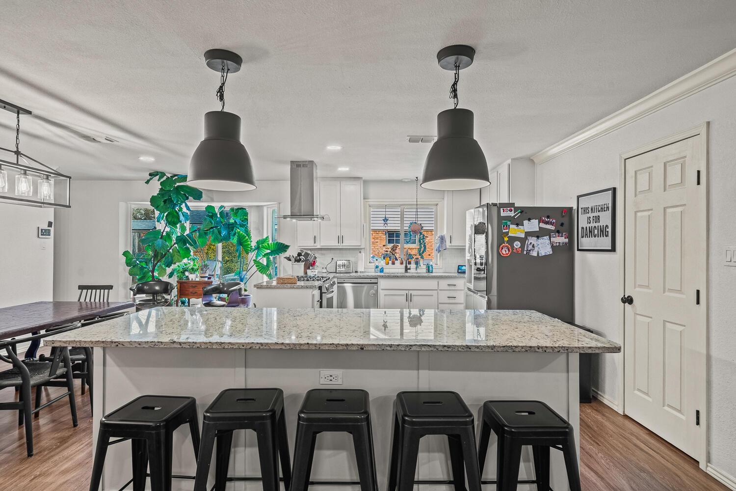 3410 94th Street Lubbock, TX 79423 - Photo 17 of 57 a kitchen with stainless steel appliances a dining table chairs and wooden floor