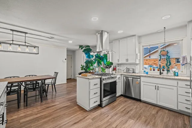 a kitchen with stainless steel appliances a stove top oven a sink and cabinets