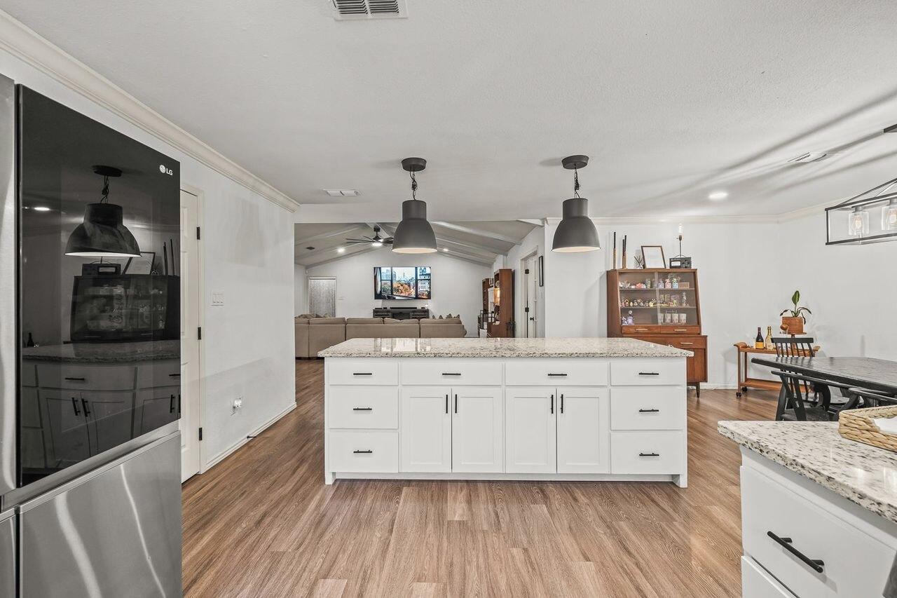 3410 94th Street Lubbock, TX 79423 - Photo 21 of 57 a kitchen with cabinets wooden floor and stainless steel appliances