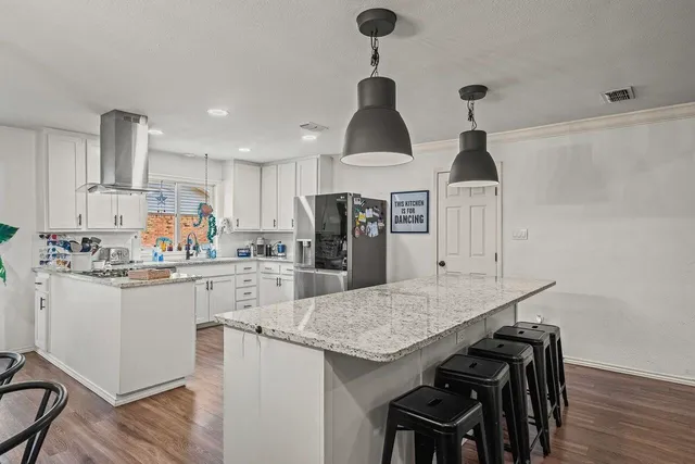 a kitchen with a dining table chairs and refrigerator
