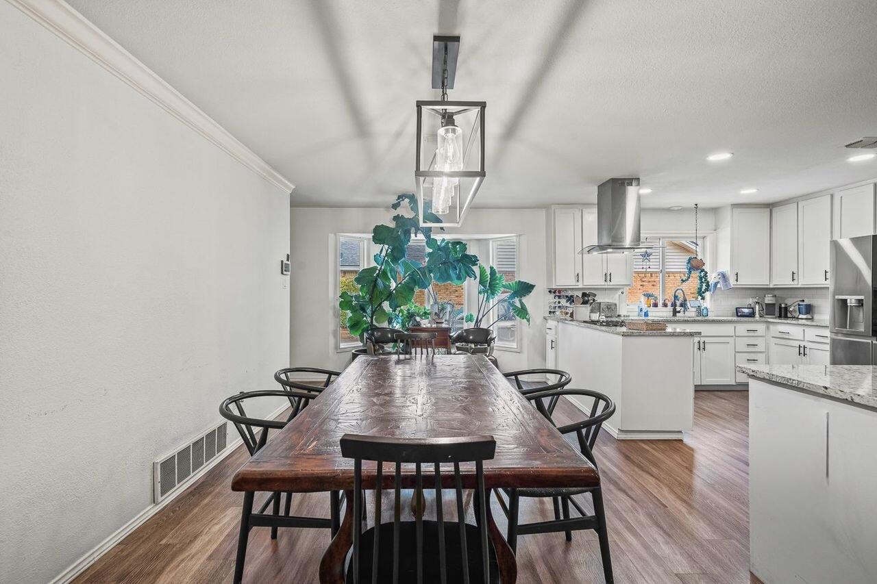 3410 94th Street Lubbock, TX 79423 - Photo 26 of 57 a kitchen with a dining table chairs and refrigerator