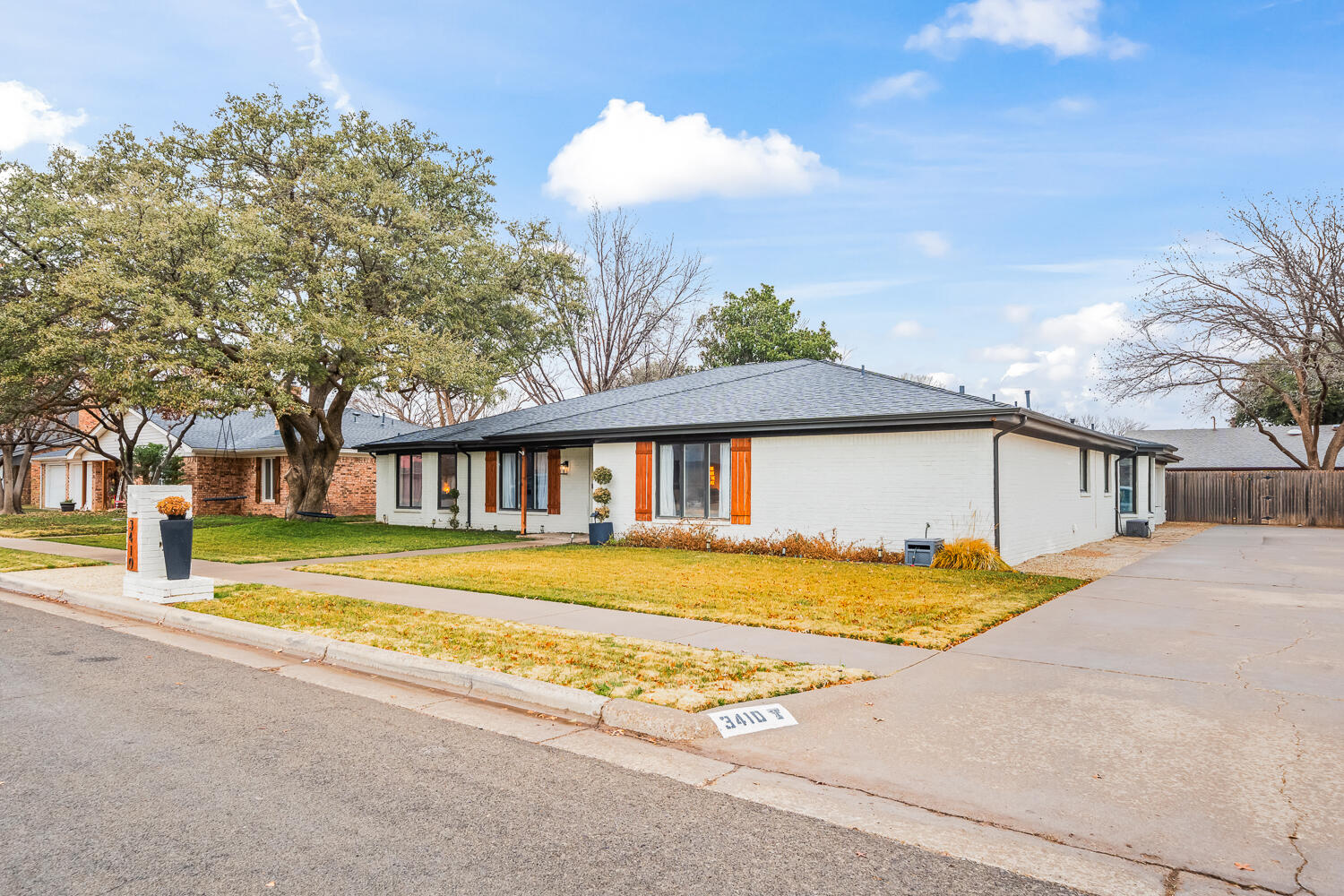 3410 94th Street Lubbock, TX 79423 - Photo 3 of 57 a view of a house with a big yard and large trees