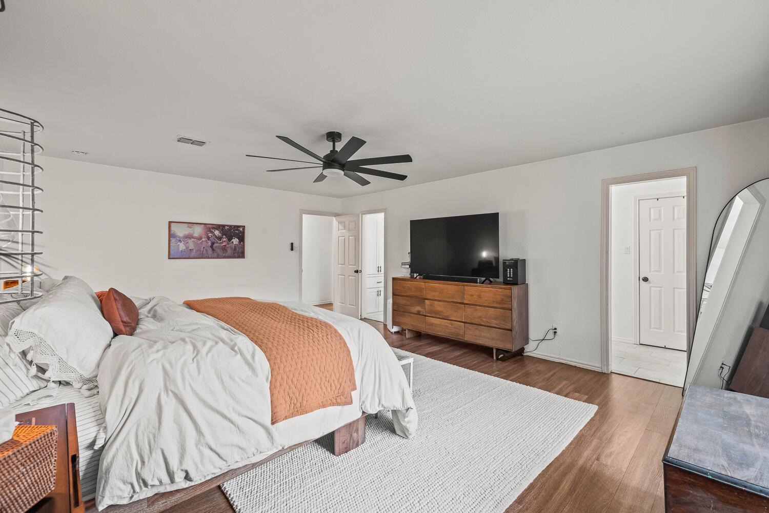 3410 94th Street Lubbock, TX 79423 - Photo 34 of 57 a bedroom with a bed a flat screen tv and a couch