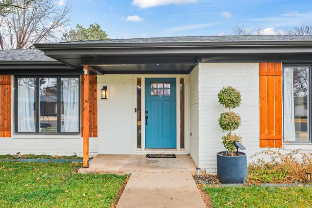 a front view of a house with potted plants
