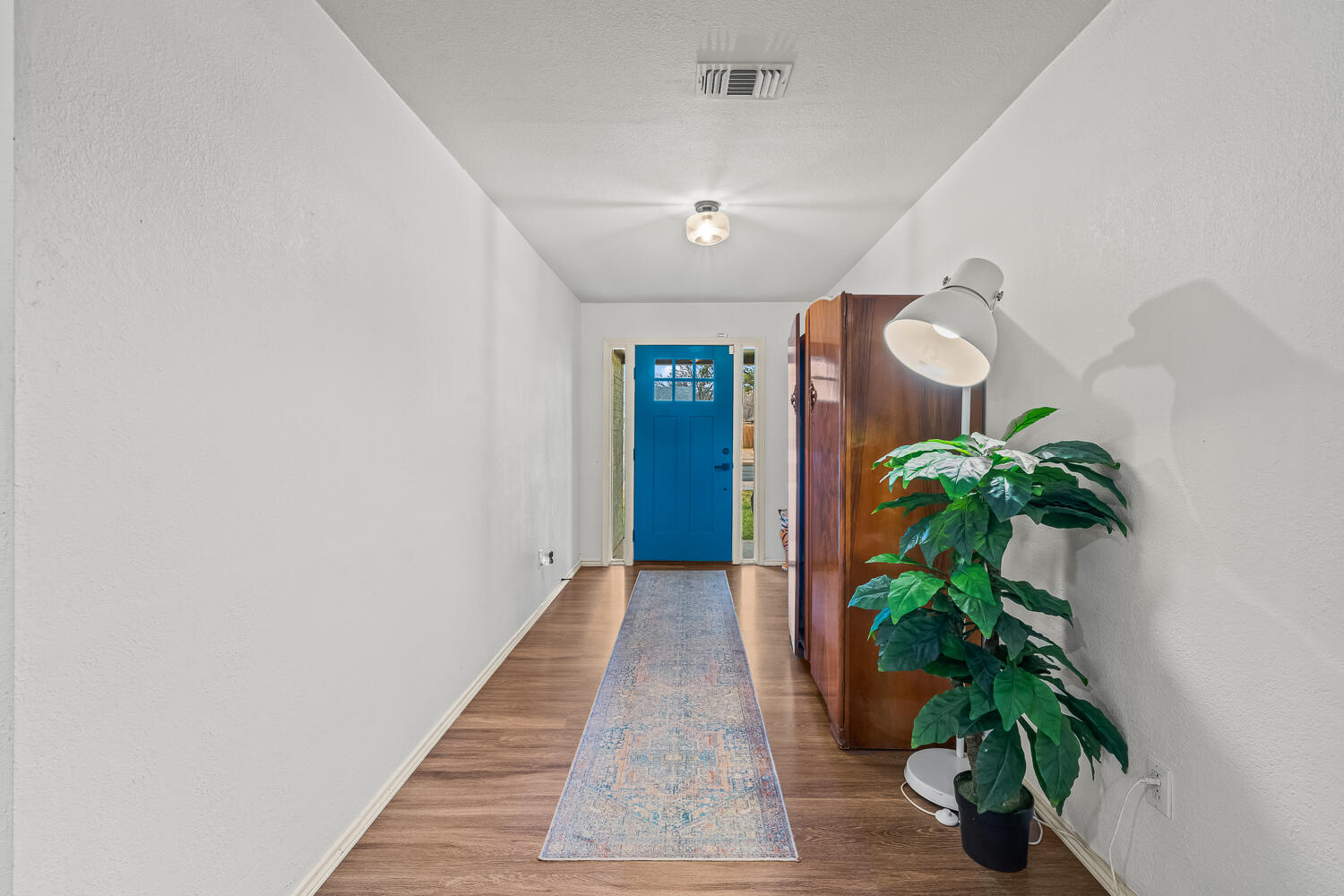 3410 94th Street Lubbock, TX 79423 - Photo 5 of 57 a hallway with potted plants and wooden floor