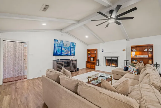 a living room with furniture and a ceiling fan