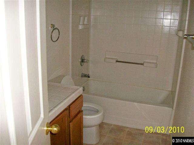 9525 Apache Rose Drive Reno, NV 89521 - Photo 11 of 13 a bathroom with a granite countertop bathtub shower sink vanity and toilet