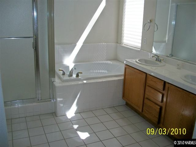 9525 Apache Rose Drive Reno, NV 89521 - Photo 8 of 13 a bathroom with a sink a toilet and a shower
