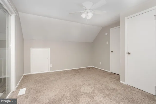 an empty room with a ceiling fan and a window