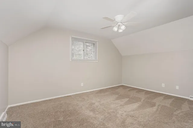 a view of an empty room with a chandelier fan