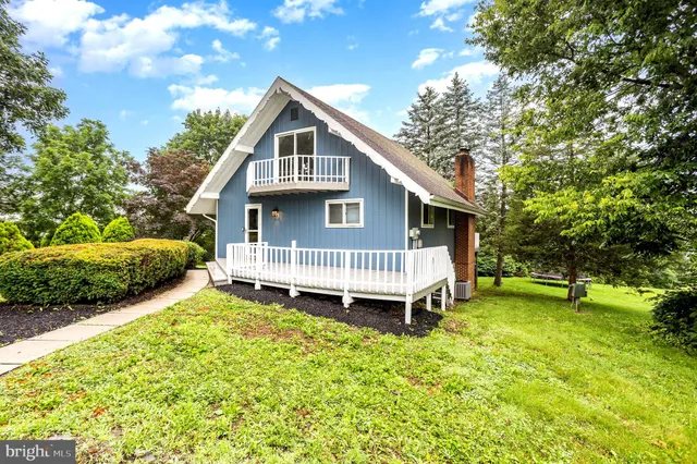 a view of a house with a yard and deck area