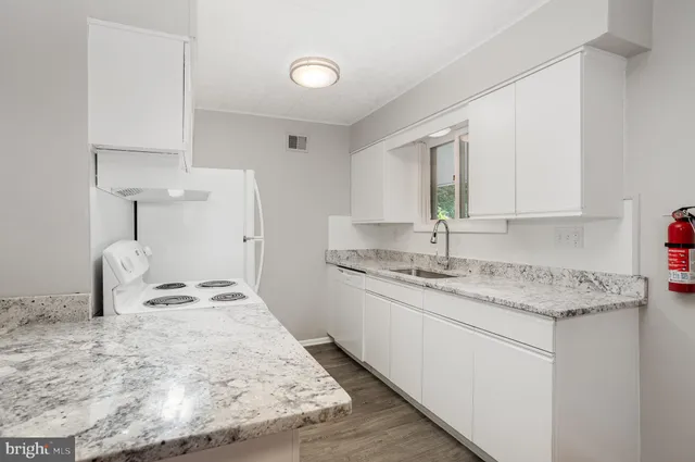 a kitchen with granite countertop sink and cabinets