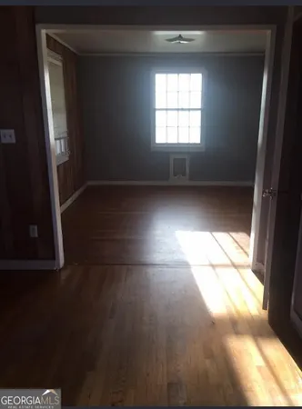 view of empty room with wooden floor and fan