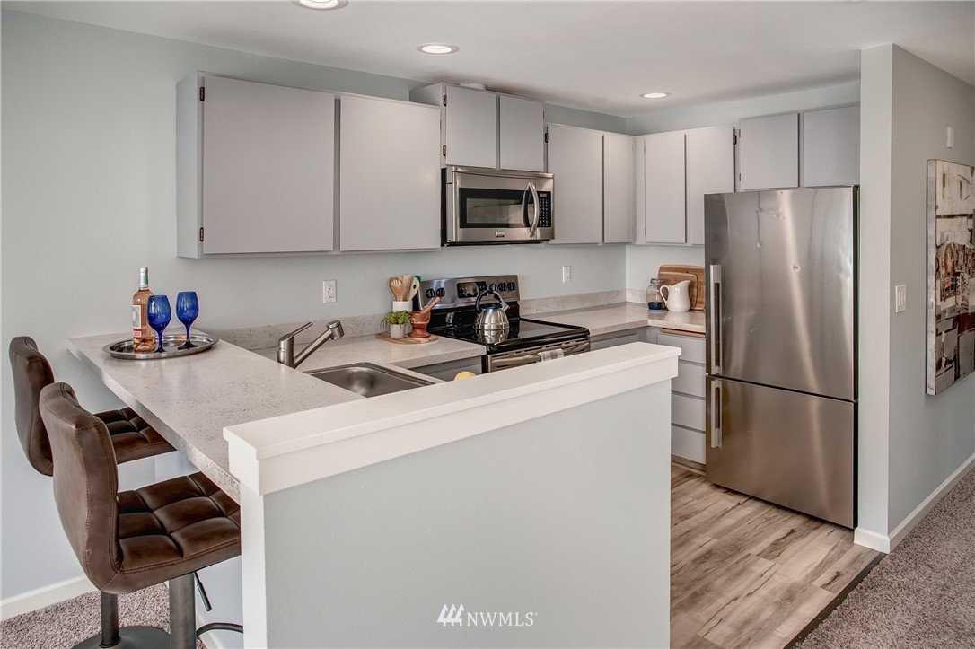 2400 East Howell Street, Unit E Seattle, WA 98122 - Photo 13 of 39 a kitchen with a sink a microwave a refrigerator and cabinets