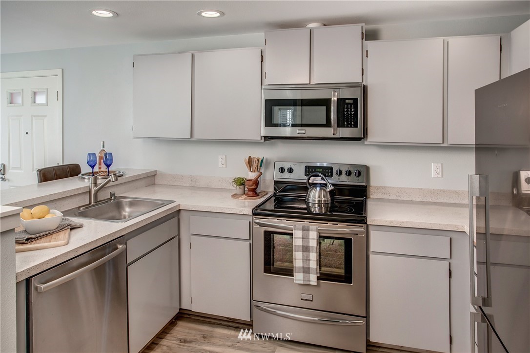2400 East Howell Street, Unit E Seattle, WA 98122 - Photo 14 of 39 a kitchen with white cabinets stainless steel appliances and sink